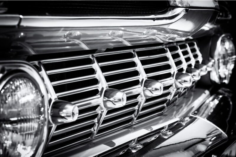 Black and white close-up of a classic car grille and headlamp at Franschhoek Car Museum, showcasing polished chrome detail. Original Nikon digital and film photography, captured with a variety of high-quality professional cameras. Medium format film images shot with professional cameras, including Pentax 645, Pentax 6x7, Mamiya 645, Fuji GX617 panoramic, Rollei, and Yashica Mat. Large format film images created using professional pinhole cameras, as well as Shen-Hao 4x5, 4x10, 5x7, and 8x10 film cameras, featuring film stocks from Adox, Bergger, Fomapan, Fuji, Ilford, Kodak, Rollei, and Shanghai GP3. All photography and copyrights by CFP Prints & Craig Fouché Photography.