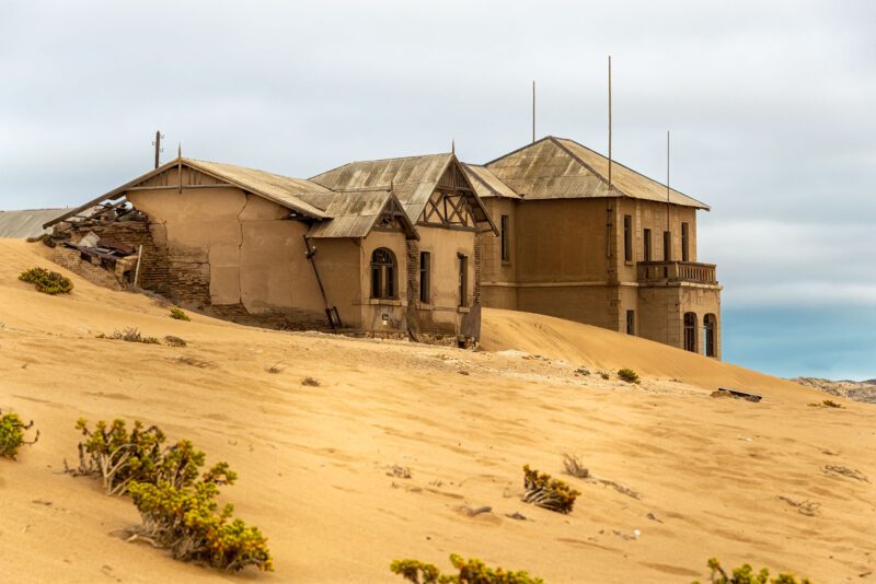 Sunlit Kolmanskop schoolhouse filled with desert sand – a colour fine art photograph symbolising wisdom, maturity, and spiritual grounding.
