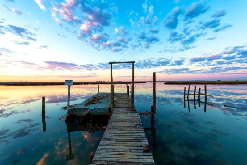 Sunrise Jetty, Cape West Coast, South Africa – weathered jetty extending into a calm estuary beneath a golden and indigo dawn sky